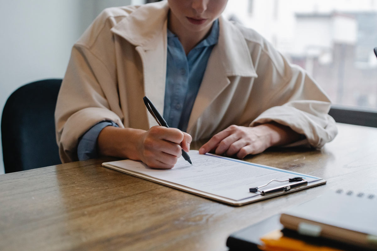 Une patiente est en train de répondre à une série de questions posées par un professionnel de la santé pendant une expertise médicale.